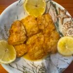 Pan-fried fish francaise coated in a buttery lemon wine sauce served over white rice