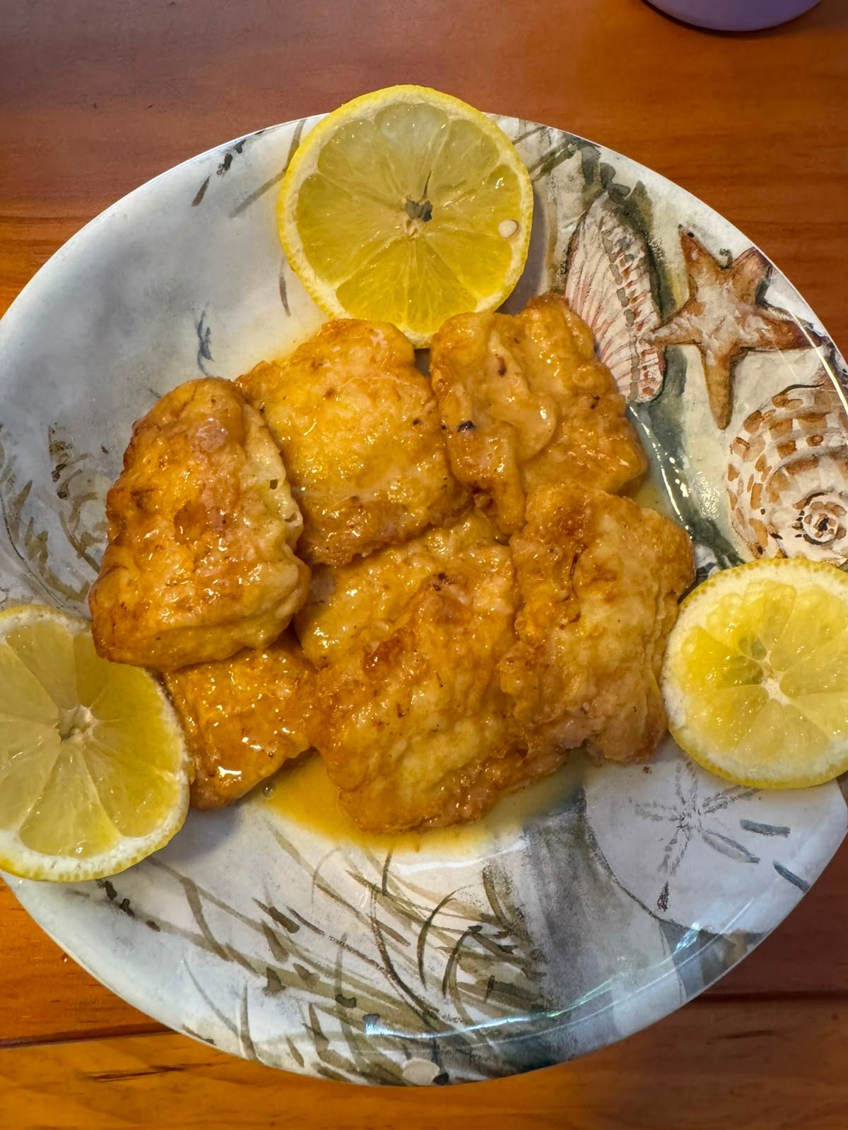 Pan-fried fish francaise coated in a buttery lemon wine sauce served over white rice